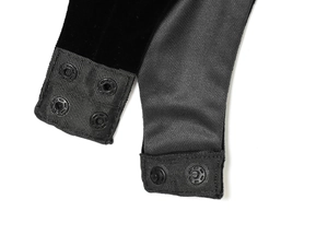 Close-up of black velvet bodysuit featuring a three-row plastic snap button closure