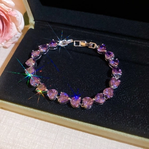 Macro detail of purple heart-shaped crystal bracelet with silver prong setting in gift box