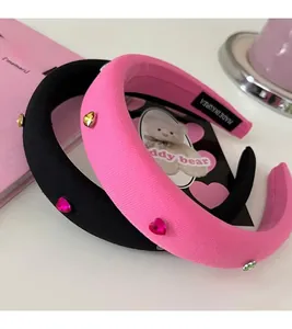 Close-up of pink and black sponge headbands with colorful rhinestone heart embellishments