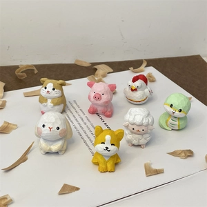 Close-up of hand-carved wooden animal miniatures including pig and rabbit on sketch book