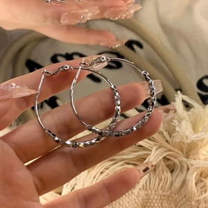 Silver hoop earrings with textured geometric pattern and polished metallic finish