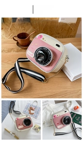 Pink and cream camera-shaped crossbody bag with striped strap and gold chain detail