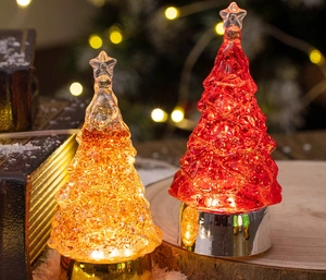 Detail of red and yellow LED crystal Christmas trees on a wooden base with festive lights