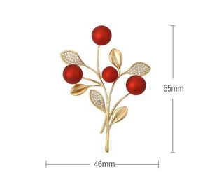 Detailed view of red berry brooch dimensions 65mm x 46mm with golden leaves and crystals