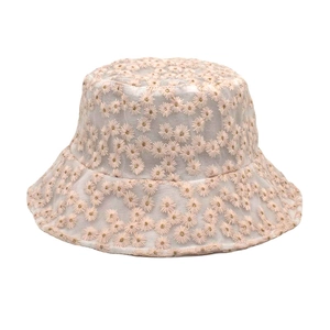 Detailed embroidery view of daisy patterns on a semi-transparent mesh sun hat