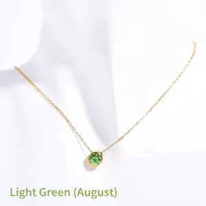 Macro detail of August birthstone necklace featuring a round light green zircon pendant