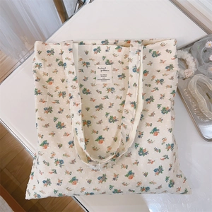 Detail of floral cotton canvas tote bag with textured jacquard and animal pattern tag