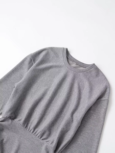 Macro detail of grey long sleeve crew neck top showing ribbed knit fabric texture