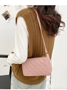 Detail of pink quilted shoulder bag worn by model showing rhombic stitching and PU leather