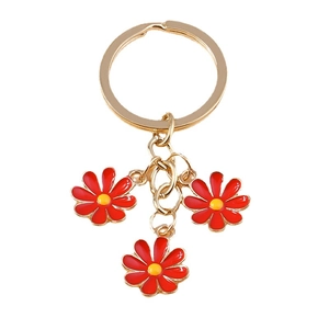 Cute red daisy flower keychain with gold metal ring and three floral charms on white background