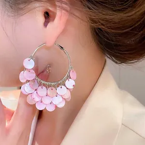 Bohemian large gold hoop earrings with layered pink shell charms for beach vacations