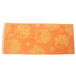 Detail of orange cotton towel with yellow floral pattern and decorative tassel fringe