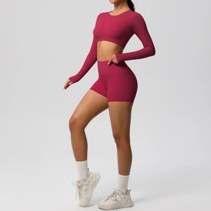 Detail view of seamless berry red long sleeve yoga top and high waist sports shorts