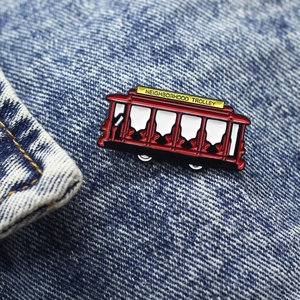 Macro shot of red enamel neighborhood trolley pin badge on dark blue denim fabric