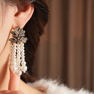 Nahaufnahme von Vintage-Quastenohrringen mit weißen Perlen und glitzernden Strasssteinen