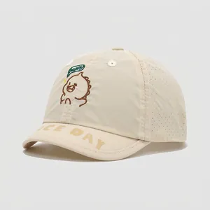 Detail van beige kinderpet met ademende lasergeperforeerde gaten en vrolijke monsterborduring