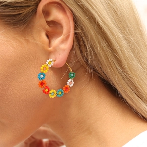 Kleurrijke handgemaakte kralen bloem oorringen in boho stijl getoond op een model
