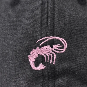 Washed charcoal cotton baseball cap with detailed pink lobster embroidery on front