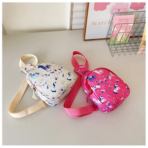 Flat lay of cream and rose pink kids canvas crossbody bags with unicorn print
