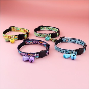 Close-up of four colorful plaid cat collars with bells, tassels and cat-shaped buckles