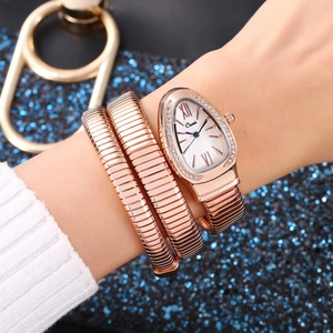 Detailed view of a rose gold snake-shaped wrap watch with crystal bezel on wrist