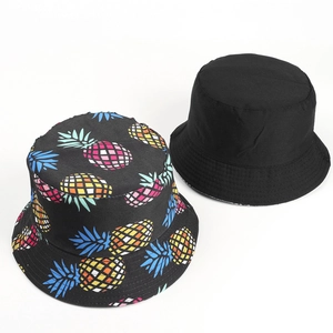 Reversible bucket hat with tropical pixelated pineapple print and classic black solid side