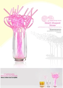 Close-up of pink heart-shaped crystal decorative straws in a glass for parties