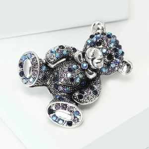 Close-up of teddy bear brooch with colorful rhinestones on silver-tone metal