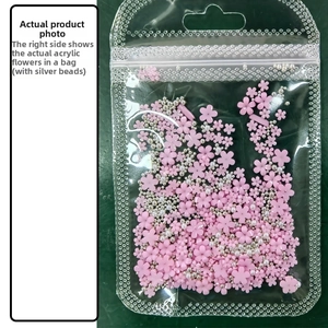 Macro detail of pink resin 5-petal flower beads and silver balls in a clear package