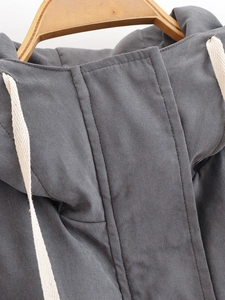 Detail of dark grey hooded jacket collar with drawstrings and fabric texture