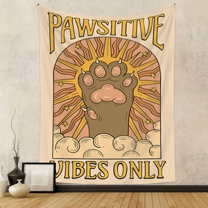 Bohemian cat paw tapestry with Pawsitive Vibes Only text hanging on a modern wall