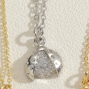 Macro shot of silver ladybug pendant with cubic zirconia pave setting on O-chain necklace