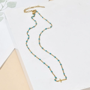 Bohemian gold stainless steel necklace featuring light blue beads and a cross pendant