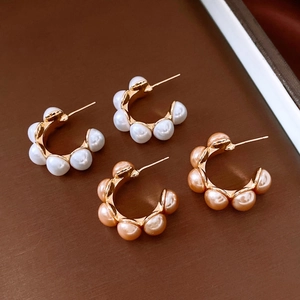 Gros plan de boucles d'oreilles en C plaquées or 18 carats avec perles blanches et roses