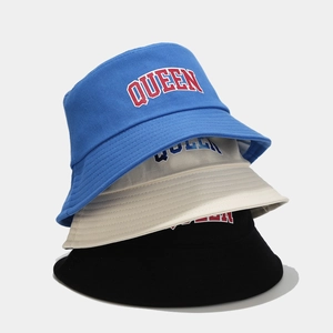 Detailed view of QUEEN embroidered bucket hats in navy blue, beige, and black colors