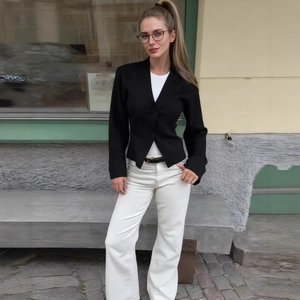 Cardigan nero slim fit con scollo a V per donna abbinato a pantaloni bianchi eleganti