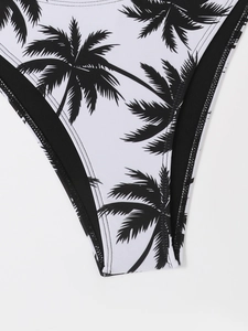 Close-up of tropical black palm leaf print on white high-cut bikini bottoms