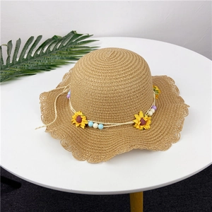 Detail of woven straw sun hat with yellow sunflowers and colorful beaded accents