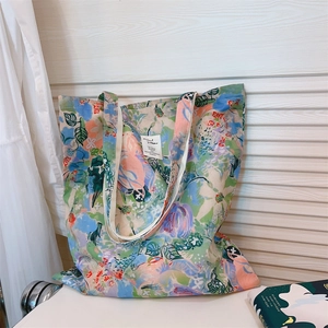 Close-up of floral oil painting canvas tote bag with artistic pattern and woven label