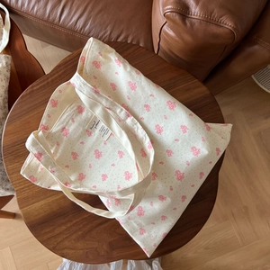 Floral print cotton canvas tote bag with pink cherry blossom pattern on a wooden table