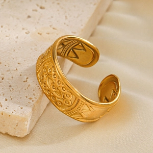 Minimalist gold bohemian open ring with ethnic embossed design on a textured stone base