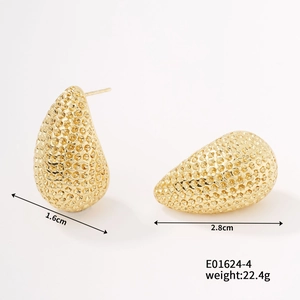 Detailed close-up of golden textured drop earrings with honeycomb hammered finish