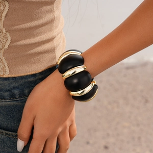 Detail of vintage acrylic chunky link bracelet in black and gold on a female wrist