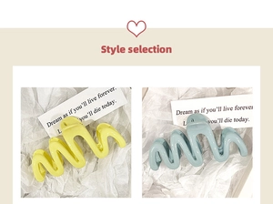 Detail of wavy S-shaped hair claws in glossy lemon yellow and soft grayish blue colors