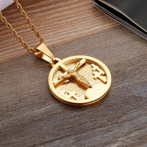 Detailed close-up of golden stainless steel cross pendant with Padre Nuestro prayer engraving