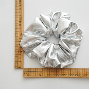 Detailed size measurement of large silver metallic scrunchie with 15cm ruler scale