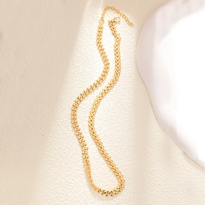 Detail of gold wheat chain necklace with lobster clasp on artistic background