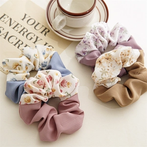 Detailed texture of floral and solid fabric scrunchies in a lifestyle setting