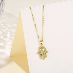Détail macro du collier pendentif Main de Fatma avec micro-pavé de zircons dorés