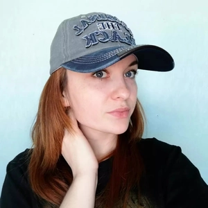 Vintage washed gray and navy baseball cap with THE BLACK embroidery on female model